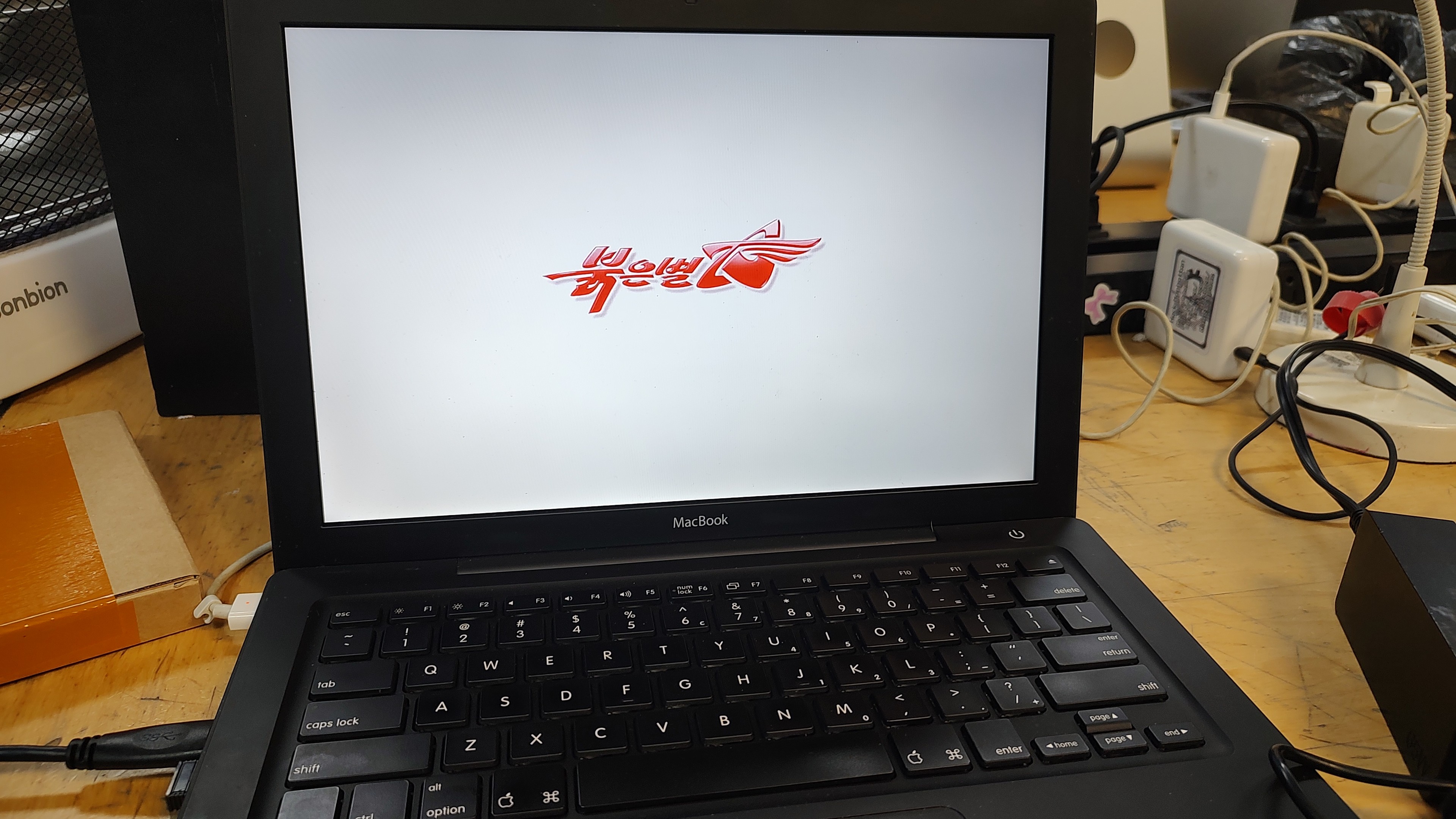 A 2006 black MacBook displaying the Red Star OS boot logo